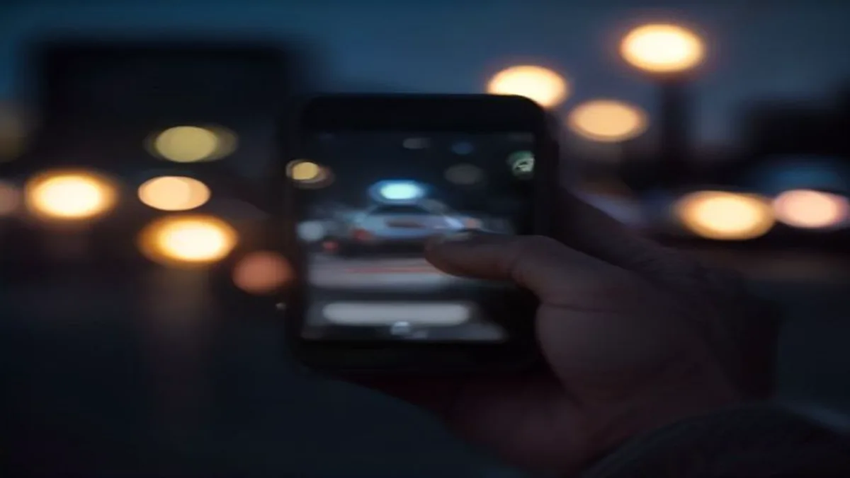 Contratista revisando su teléfono al atardecer junto a su troca de trabajo